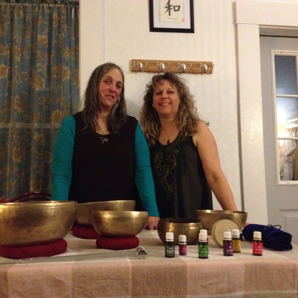 Kate and Terrie at the table with the Tibetan bowls, weighted tuning fork, and Young Living oils.